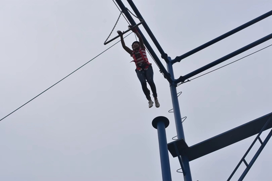 企业员工在进行空中抓杠的高空拓展