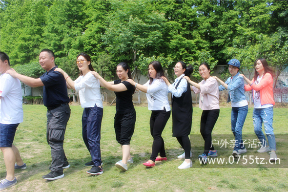 企业员工在进行户外亲子游的热身舞蹈